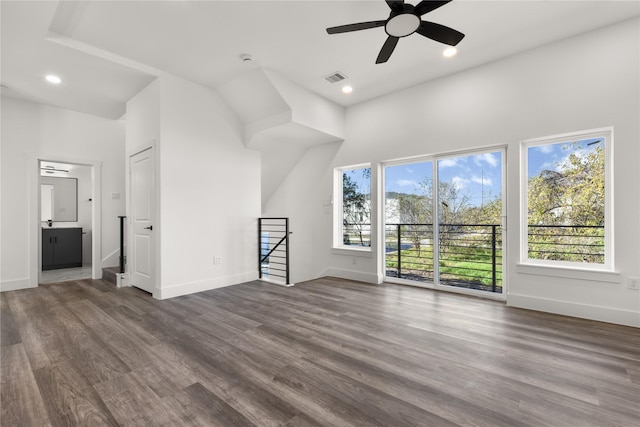 unfurnished living room with dark hardwood / wood-style flooring and ceiling fan