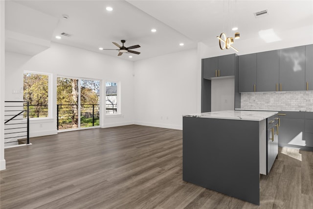 living room featuring ceiling fan with notable chandelier and dark hardwood / wood-style floors