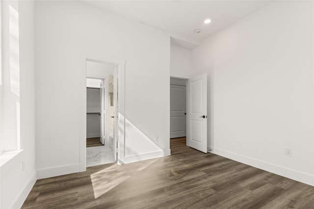 unfurnished bedroom with dark hardwood / wood-style flooring and connected bathroom