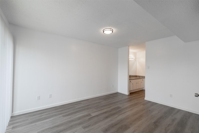 unfurnished room with dark hardwood / wood-style flooring and a textured ceiling