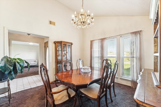 carpeted dining space featuring a notable chandelier and high vaulted ceiling