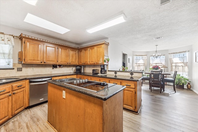 kitchen featuring tasteful backsplash, decorative light fixtures, black electric cooktop, stainless steel dishwasher, and a kitchen island