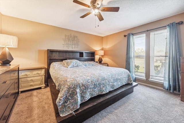 carpeted bedroom featuring a textured ceiling and ceiling fan