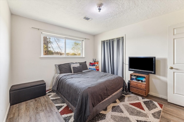 bedroom with light hardwood / wood-style flooring and a textured ceiling