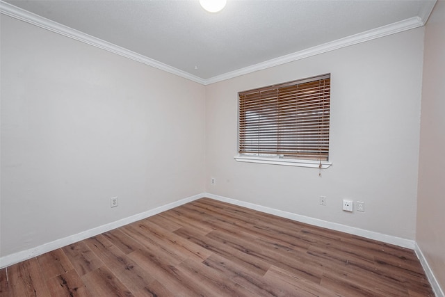 empty room with wood-type flooring and ornamental molding