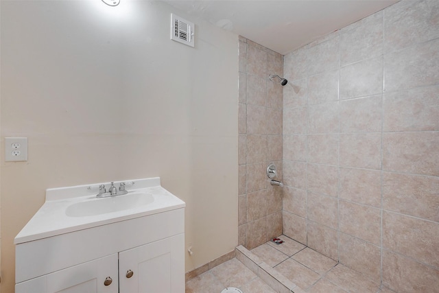 bathroom with vanity and a tile shower