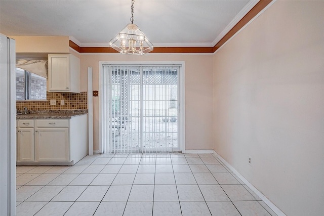 unfurnished dining area featuring light tile patterned flooring, ornamental molding, and an inviting chandelier