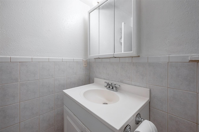 bathroom with vanity and tile walls