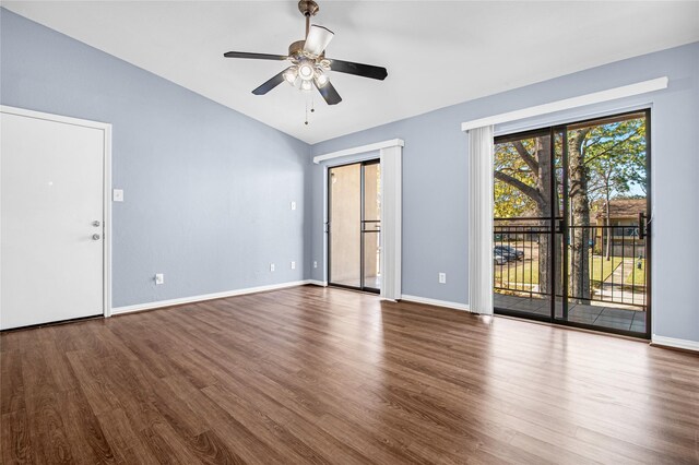 spare room featuring vaulted ceiling, wood finished floors, ceiling fan, and baseboards