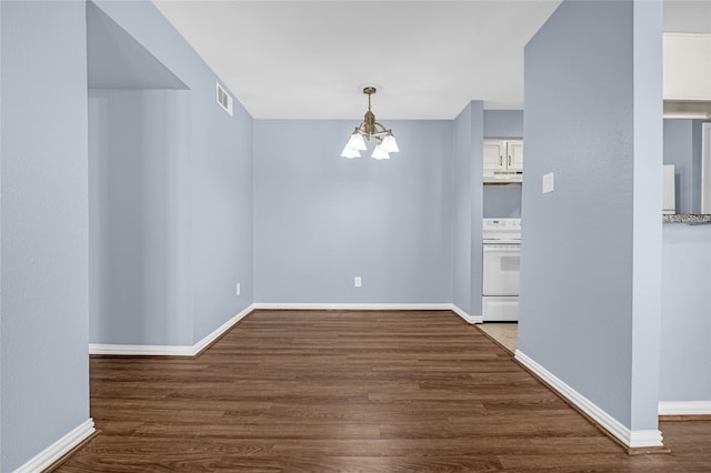 unfurnished dining area featuring dark hardwood / wood-style floors and a chandelier