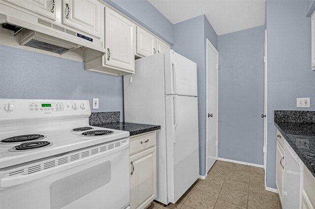 kitchen featuring white appliances, under cabinet range hood, white cabinets, light tile patterned floors, and baseboards