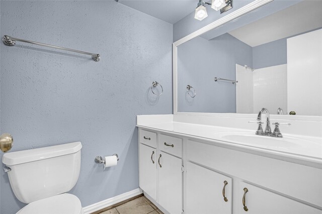 full bathroom featuring toilet, tile patterned floors, vanity, and baseboards