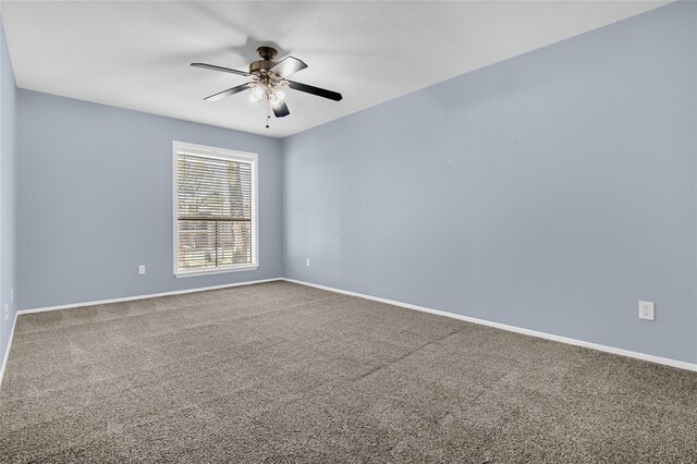unfurnished room with a ceiling fan, carpet floors, and baseboards