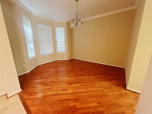 unfurnished room with a notable chandelier, hardwood / wood-style flooring, and ornamental molding