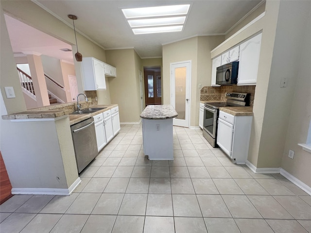 kitchen with appliances with stainless steel finishes, sink, white cabinets, decorative backsplash, and ornamental molding