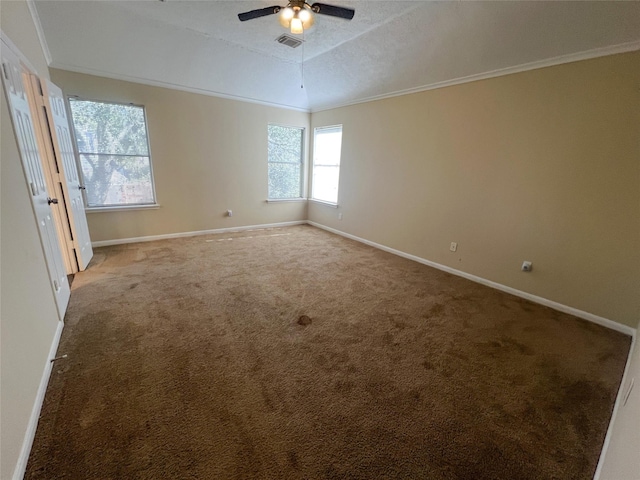 carpeted spare room with a raised ceiling, crown molding, and ceiling fan