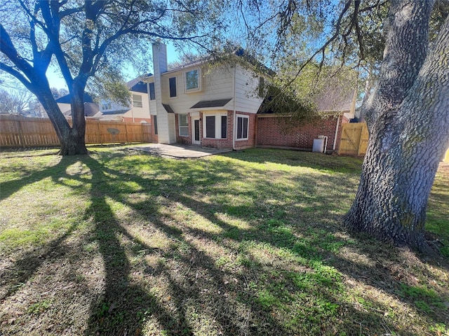 back of property with a yard and a patio area