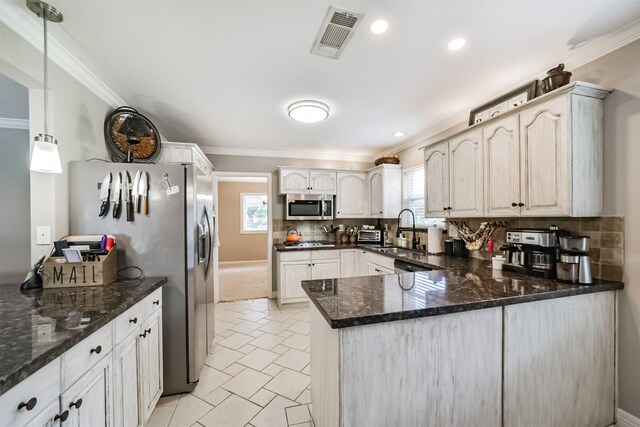 kitchen with sink, backsplash, hanging light fixtures, kitchen peninsula, and stainless steel appliances