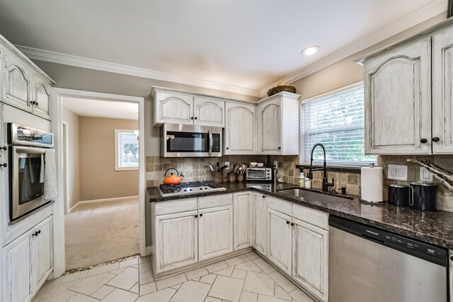 kitchen featuring sink, light carpet, appliances with stainless steel finishes, dark stone counters, and backsplash