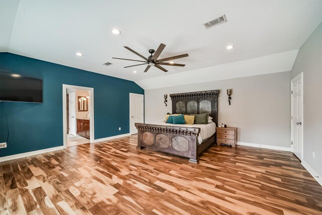 bedroom with ceiling fan, ensuite bath, vaulted ceiling, and wood-type flooring