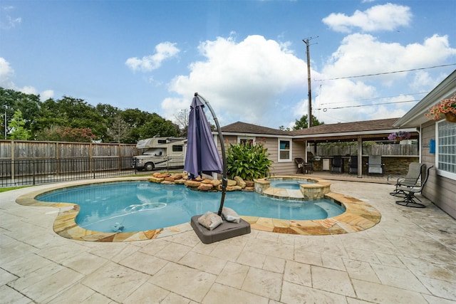 view of pool featuring a patio and an in ground hot tub