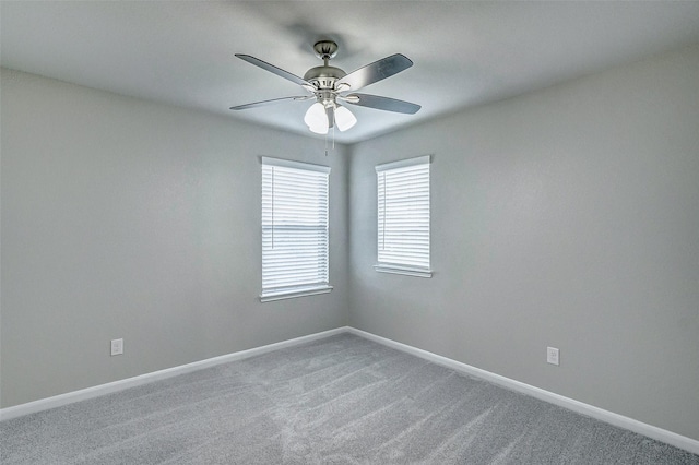 carpeted spare room with ceiling fan