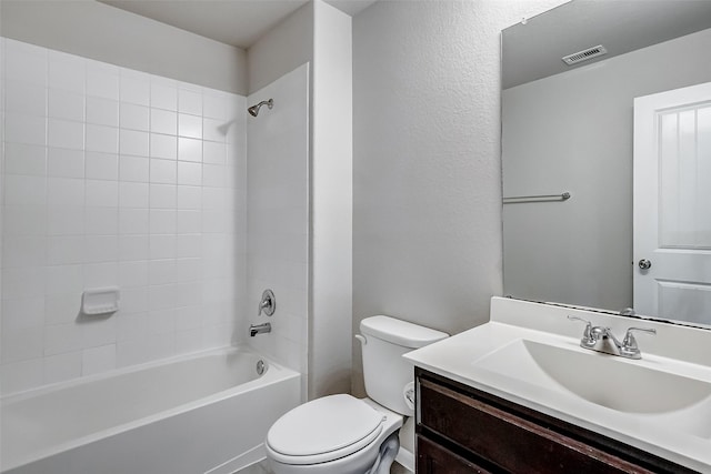 full bathroom featuring tiled shower / bath, vanity, and toilet