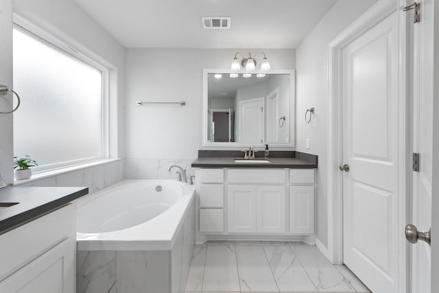 bathroom featuring vanity and tiled bath