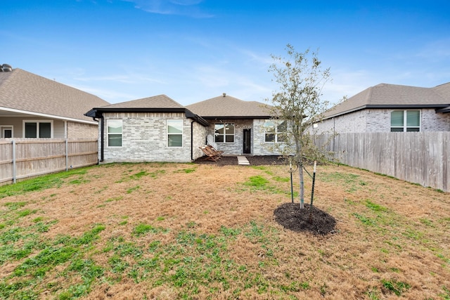 back of house featuring a lawn