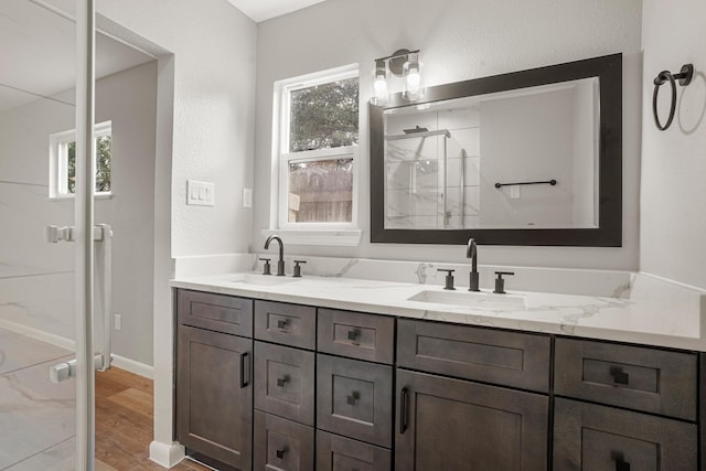 bathroom featuring hardwood / wood-style flooring, vanity, a wealth of natural light, and an enclosed shower