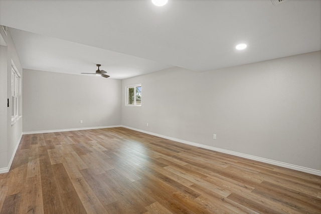 spare room featuring baseboards, a ceiling fan, and light wood-style floors