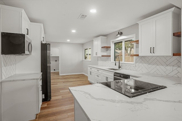 kitchen with open shelves, visible vents, appliances with stainless steel finishes, white cabinets, and light stone countertops