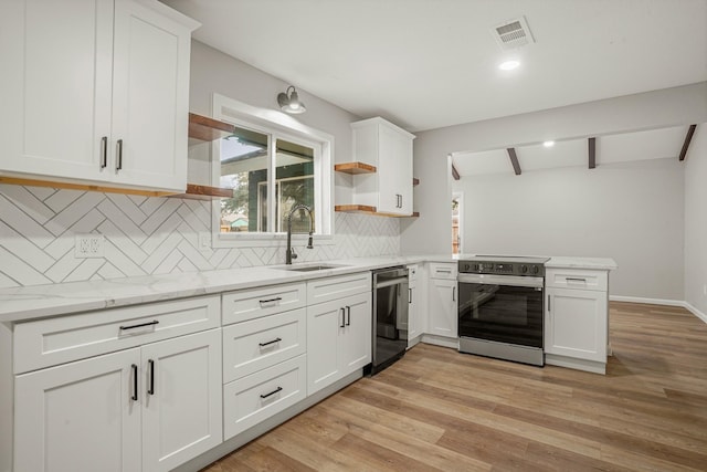 kitchen featuring open shelves, visible vents, appliances with stainless steel finishes, a sink, and a peninsula