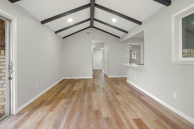 unfurnished living room featuring light wood-type flooring, visible vents, lofted ceiling with beams, and baseboards