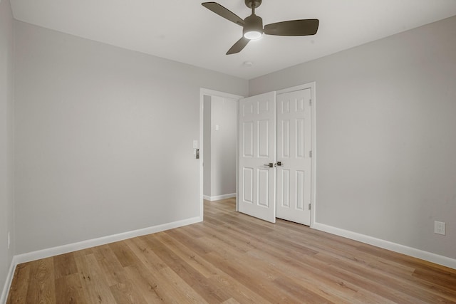 unfurnished bedroom with light hardwood / wood-style flooring, a closet, and ceiling fan