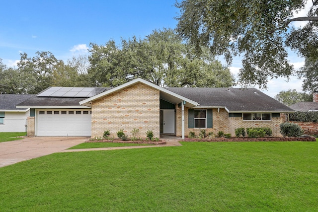 ranch-style home with a garage, a front yard, and solar panels