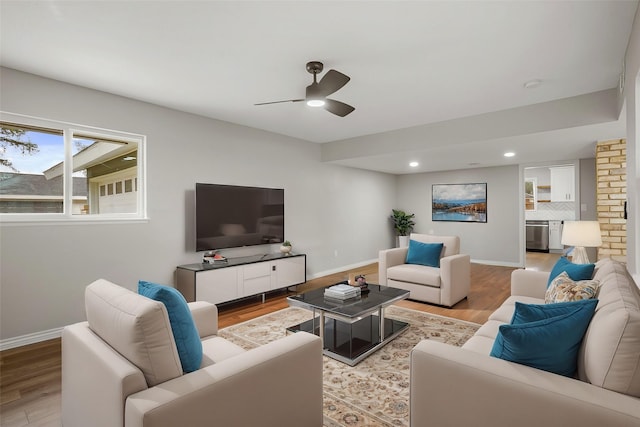 living area featuring light wood finished floors, ceiling fan, baseboards, and recessed lighting