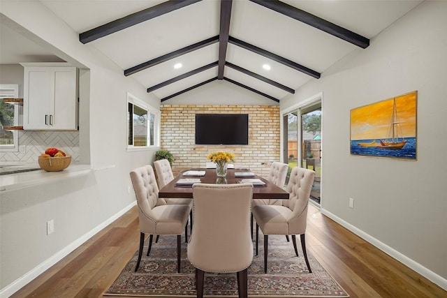 dining room featuring dark wood finished floors, vaulted ceiling with beams, and baseboards