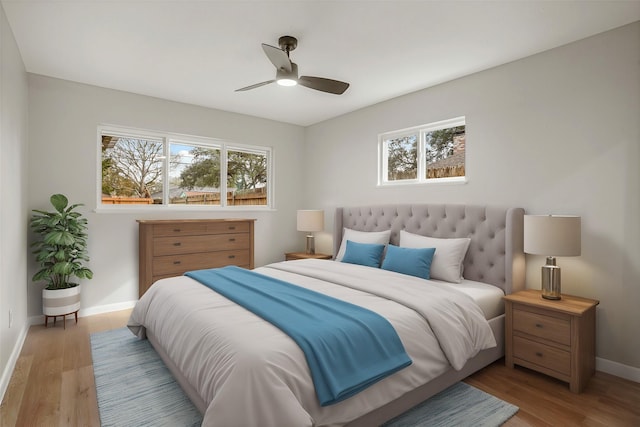 bedroom featuring ceiling fan, multiple windows, baseboards, and wood finished floors