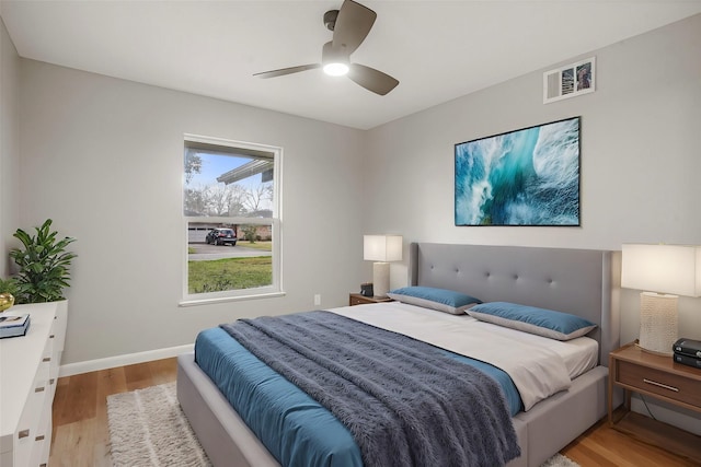 bedroom with light wood-type flooring, visible vents, ceiling fan, and baseboards