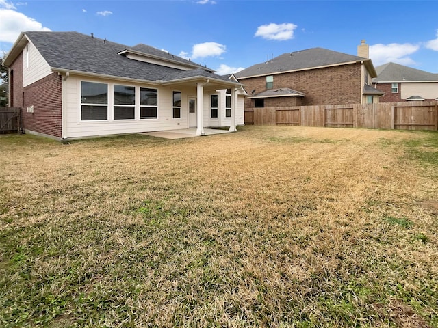 rear view of property featuring a patio area and a lawn