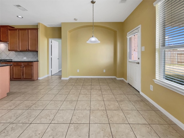 kitchen featuring tasteful backsplash, decorative light fixtures, and light tile patterned floors