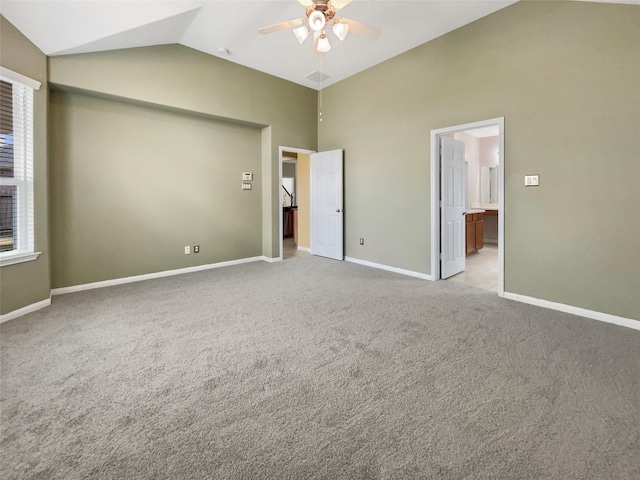 unfurnished bedroom featuring light carpet, vaulted ceiling, ceiling fan, and ensuite bathroom