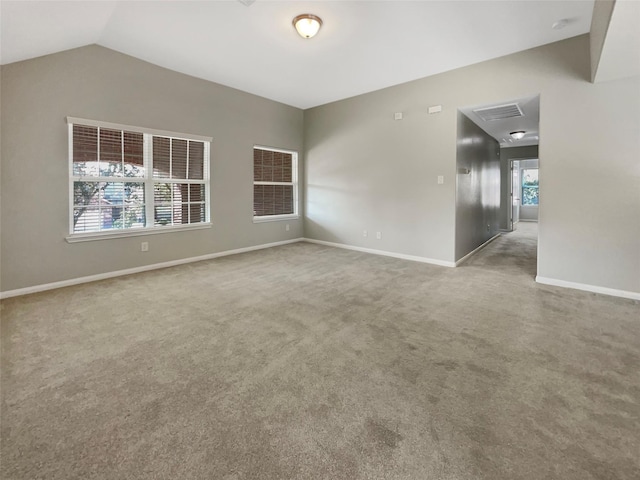 unfurnished room featuring carpet floors and vaulted ceiling