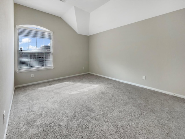 unfurnished room with carpet flooring and vaulted ceiling