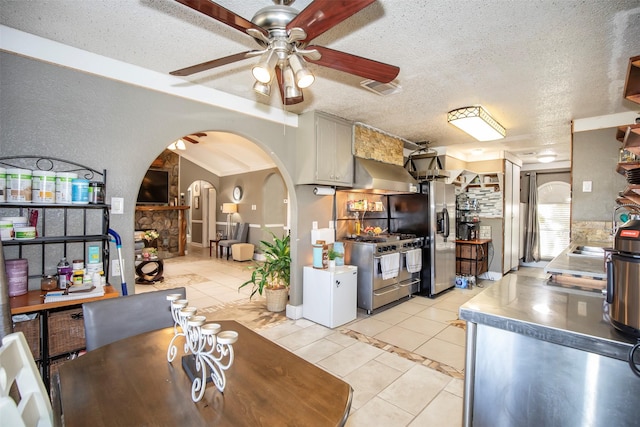 tiled dining room featuring ceiling fan and a textured ceiling