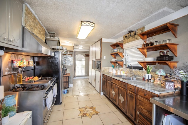 kitchen with light tile patterned flooring, appliances with stainless steel finishes, sink, and a wealth of natural light