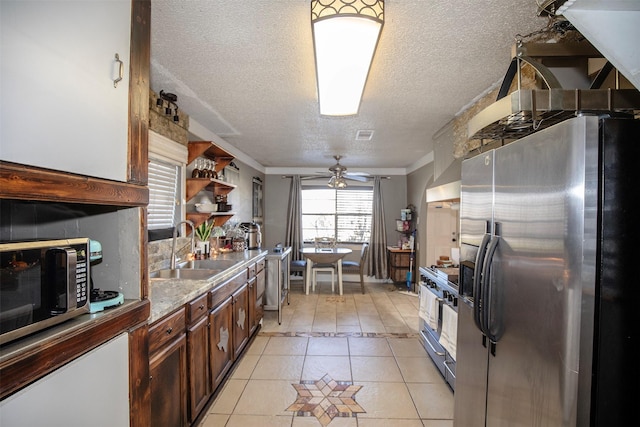 kitchen with sink, light tile patterned floors, ceiling fan, appliances with stainless steel finishes, and a textured ceiling