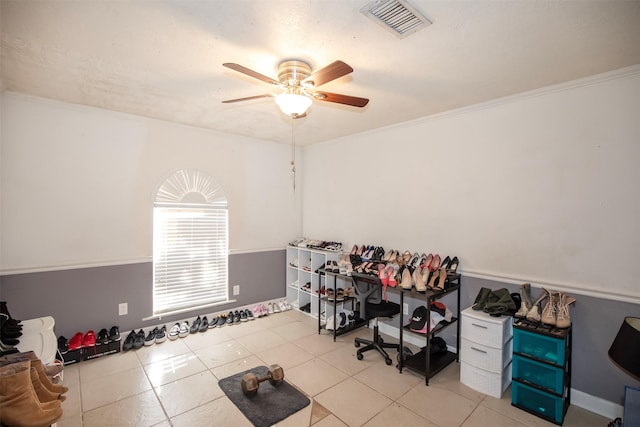 interior space featuring ceiling fan, ornamental molding, and light tile patterned floors