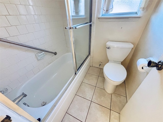 full bath with bath / shower combo with glass door, toilet, and tile patterned floors